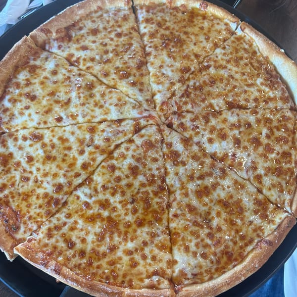 A large, round cheese pizza, cut into eight slices, with a golden-brown crust.
